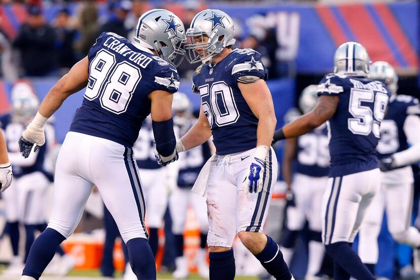 Dallas Cowboys defensive end Tyrone Crawford (98) slaps hands and bumps heads with middle...