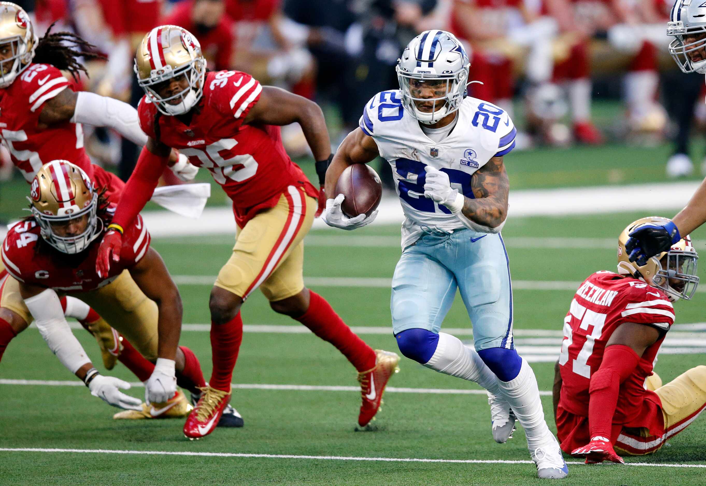 Dallas Cowboys running back Tony Pollard (20) breaks away from San Francisco 49ers defense...