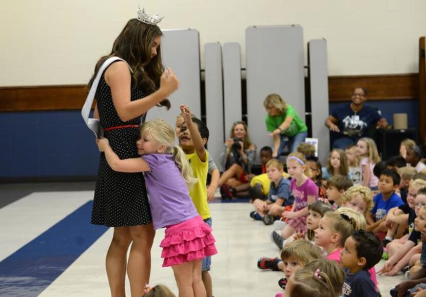 
Kindergartener Ryan Adams hugs Miss Texas Monique Evans during an assembly at Saigling...