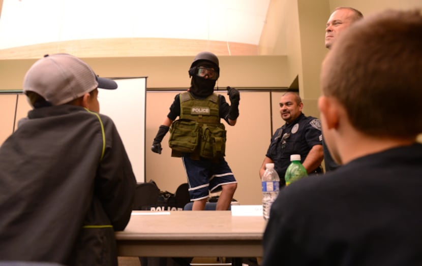 Ryan Lynch, 11, tries on Rowlett S.W.A.T. gear during the first youth police academy. The...
