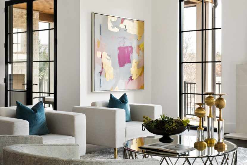 A living room features neutral chairs and white walls.