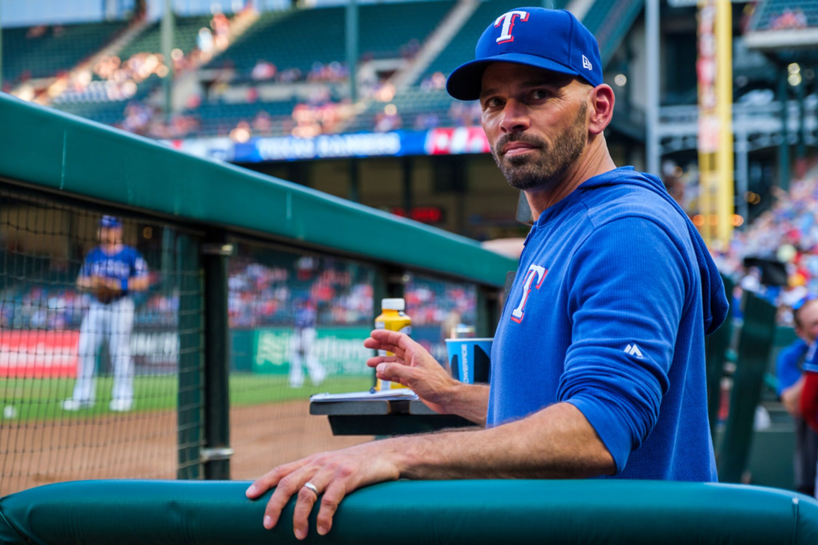 Texas Rangers manager Chris Woodward watches from the dugout before a game against the...