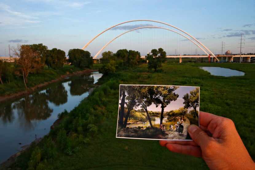  A photograph of the proposed Trinity River park area is held in front of the Interstate 30...