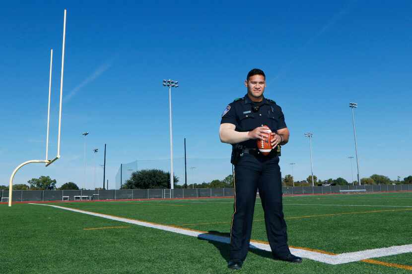 Euless police Officer Eric Fieilo stands on the practice football field at Trinity High...