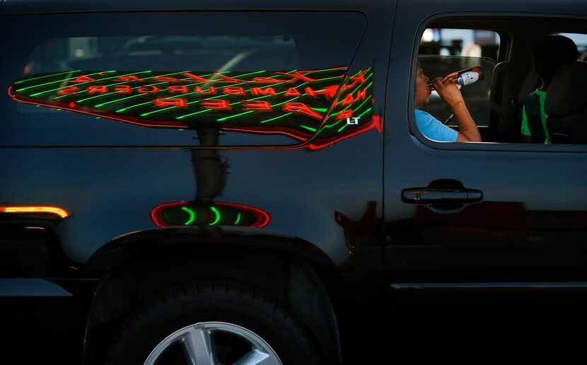 The Keller's Drive-In sign is reflected in a parked SUV at the burger and beer joint.