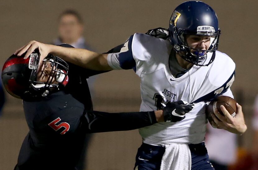 Irving MacArthur’s Darius Kirksey (5) tries to tackle Jesuit’s Jacob Palisch (17) during...