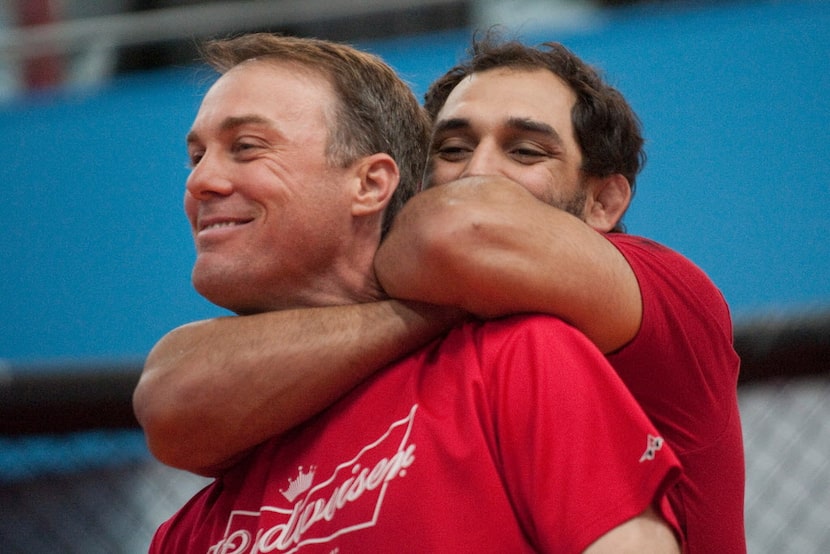 MMA fighter Johny Hendricks (right) shows NASCAR driver Kevin Harvick (left) how to put a...