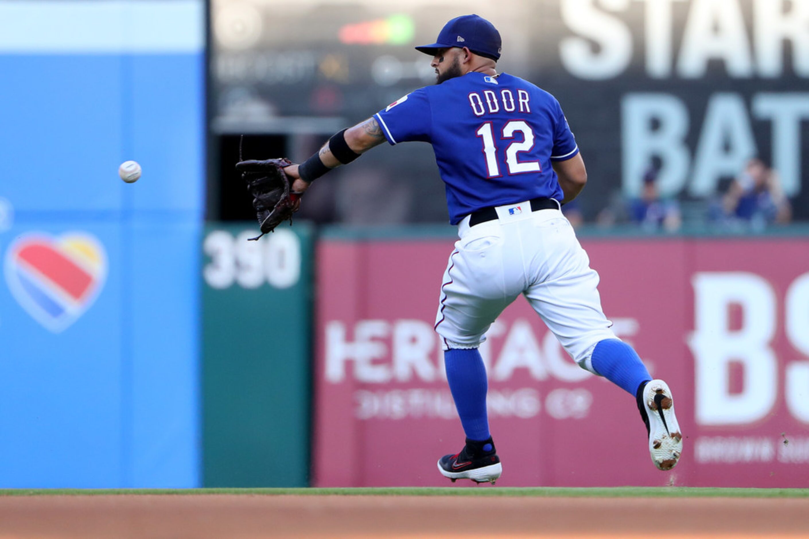 ARLINGTON, TEXAS - AUGUST 16: Rougned Odor #12 of the Texas Rangers fields a ground ball...