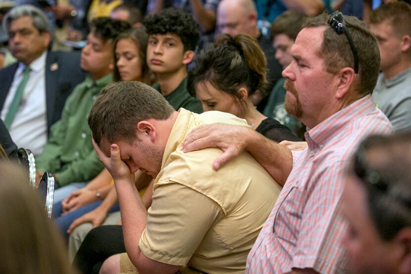 Santa Fe High School student Aaron Chenowith is comforted by his father, Richard Chenowith,...