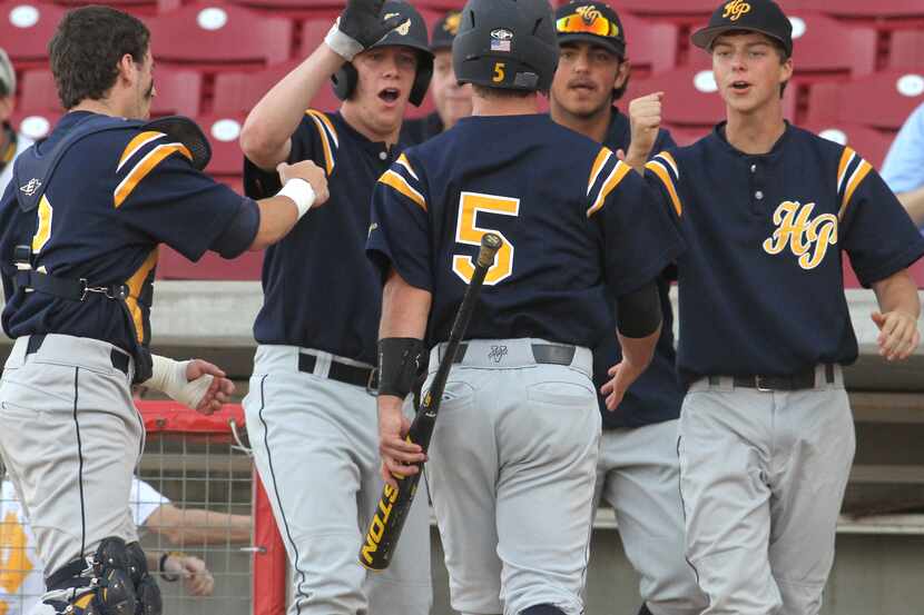 Highland Park 3rd baseman Dylan May (5) is congratulated by fellow Scots after scoring in...