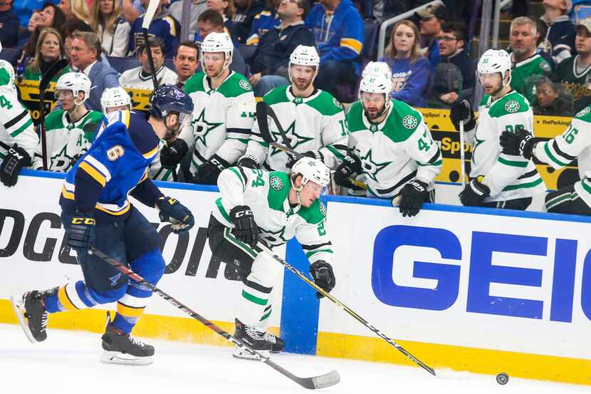 Stars left wing Roope Hintz (24) drives the puck past his team's bench while defended by St....