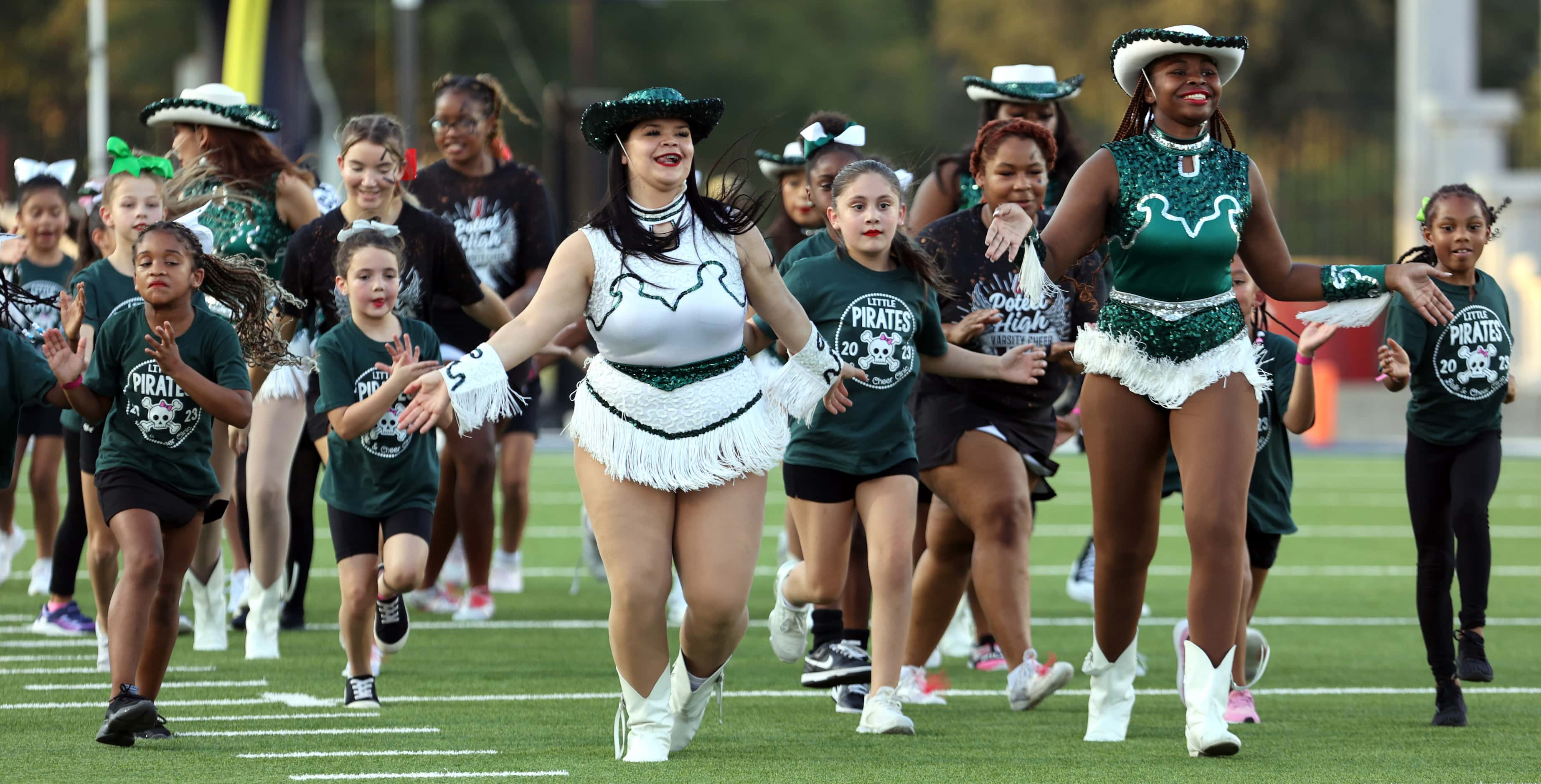 Mesquite Poteet high drill team members and elementary students run onto the field before...
