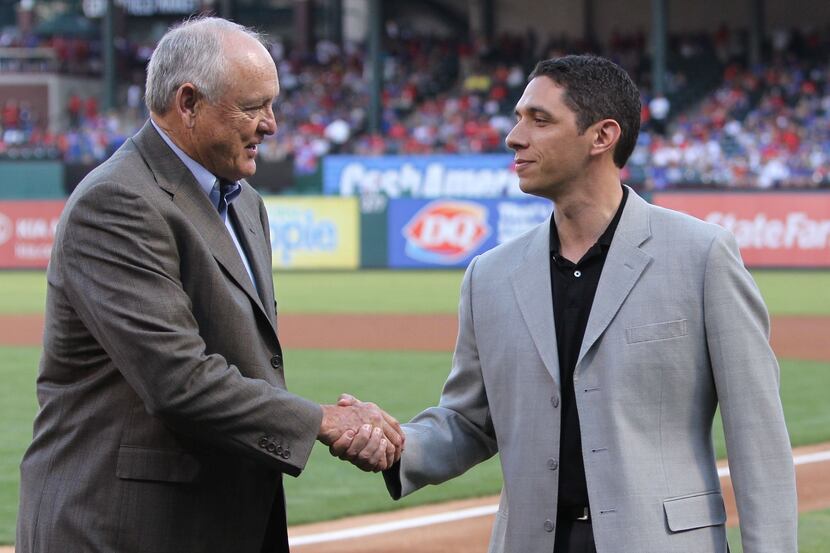 Texas president Nolan Ryan, left, and general manager Jon Daniels shake hands before the...