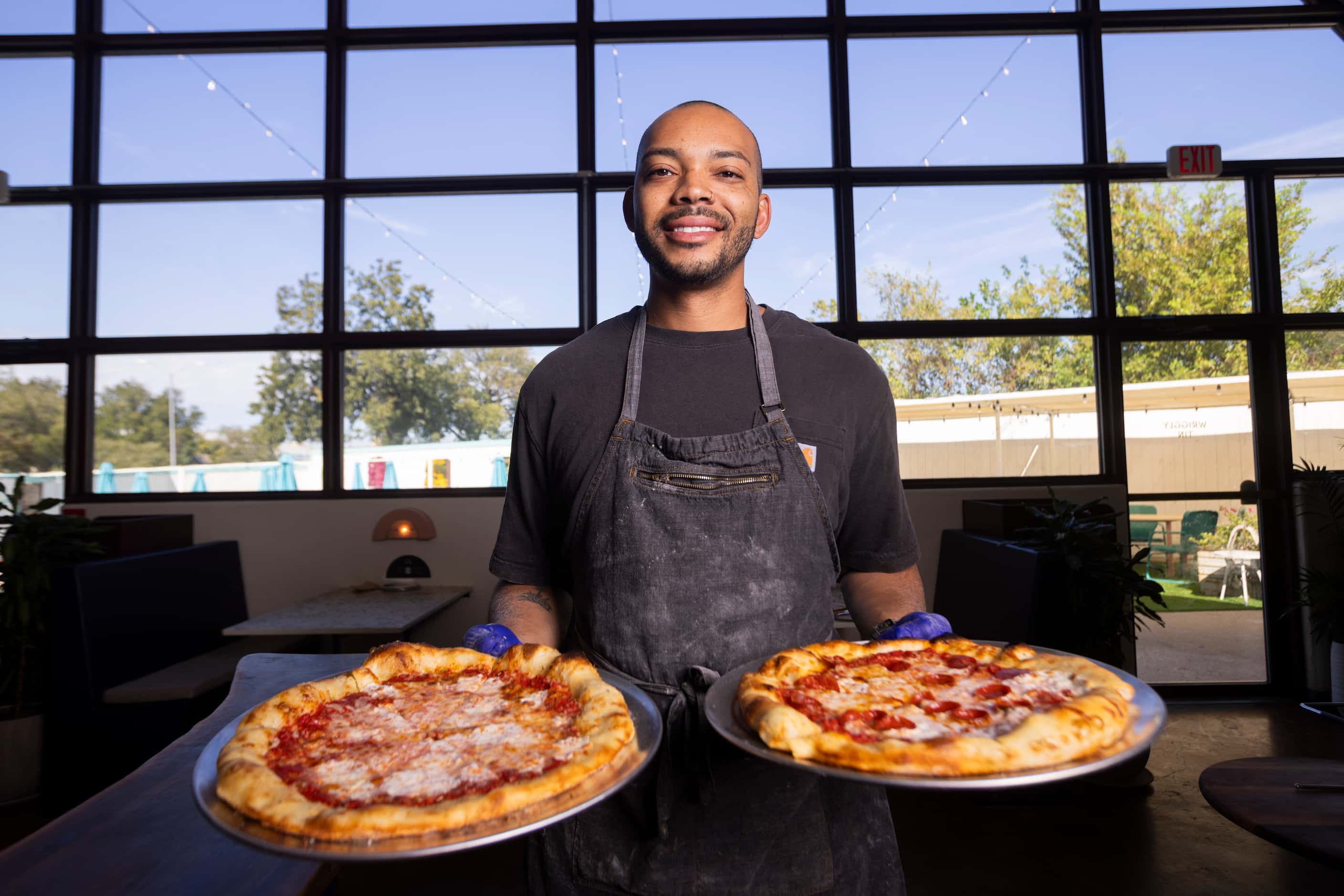 Chef Desmon Coleman holds the Red Pizza and Pepperoni Pizza served at the Wriggly Tin, a new...