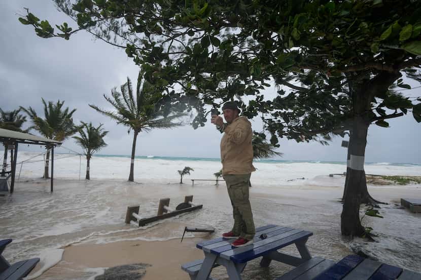 Rick Burn takes photos of damages caused by Hurricane Beryl in Hastings, Barbados, Monday,...
