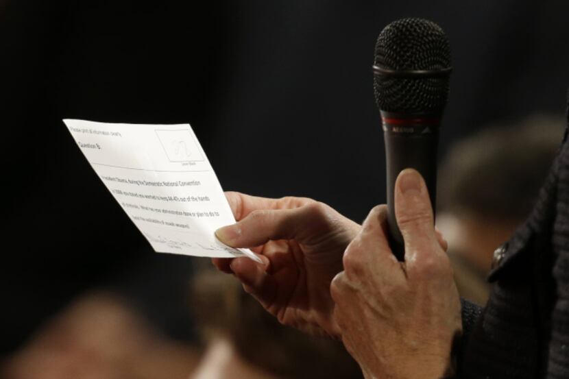 An audience member reads from a printed question during the second presidential debate at...