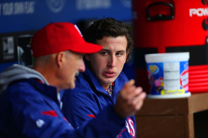 ARLINGTON, TX - APRIL 10: Derek Holland #45 talks with Mike Maddux #31 pitching coach of the...