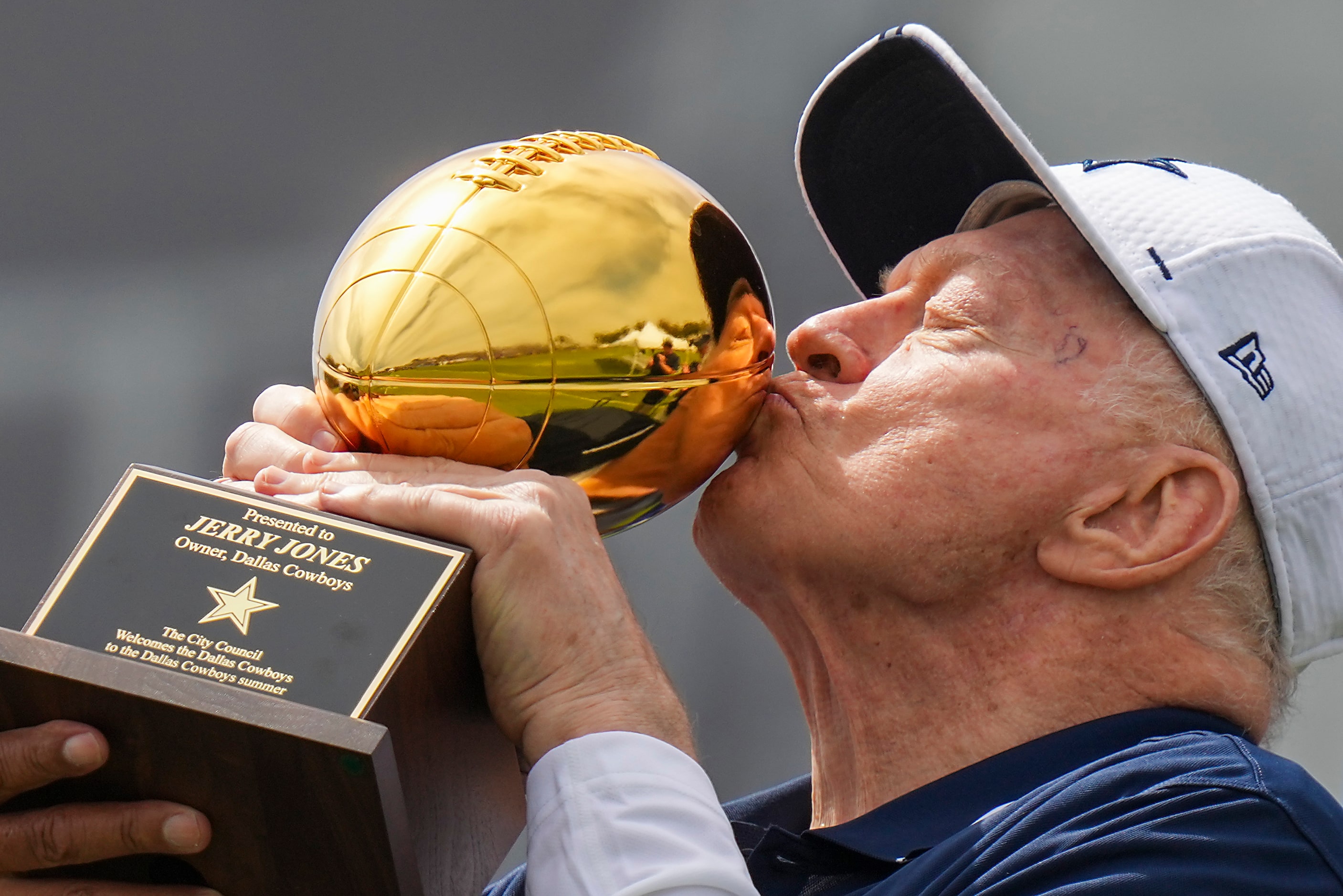 Dallas Cowboys owner and general manager Jerry Jones kisses a trophy presented to him by...