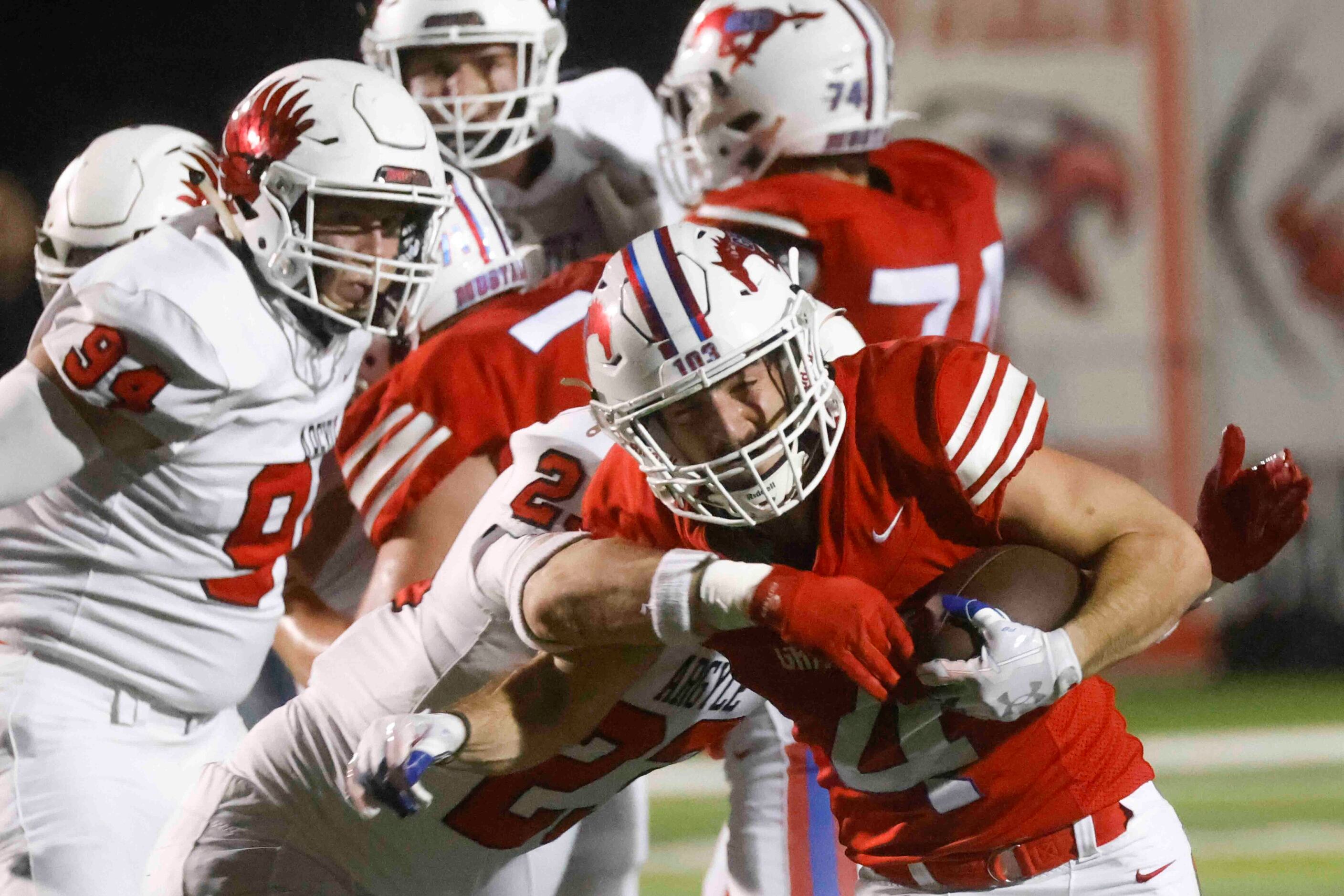 Grapevine High’s Parker Polk (4), right, gets tackled by Argyle High’s Hudson Emeterio (23),...