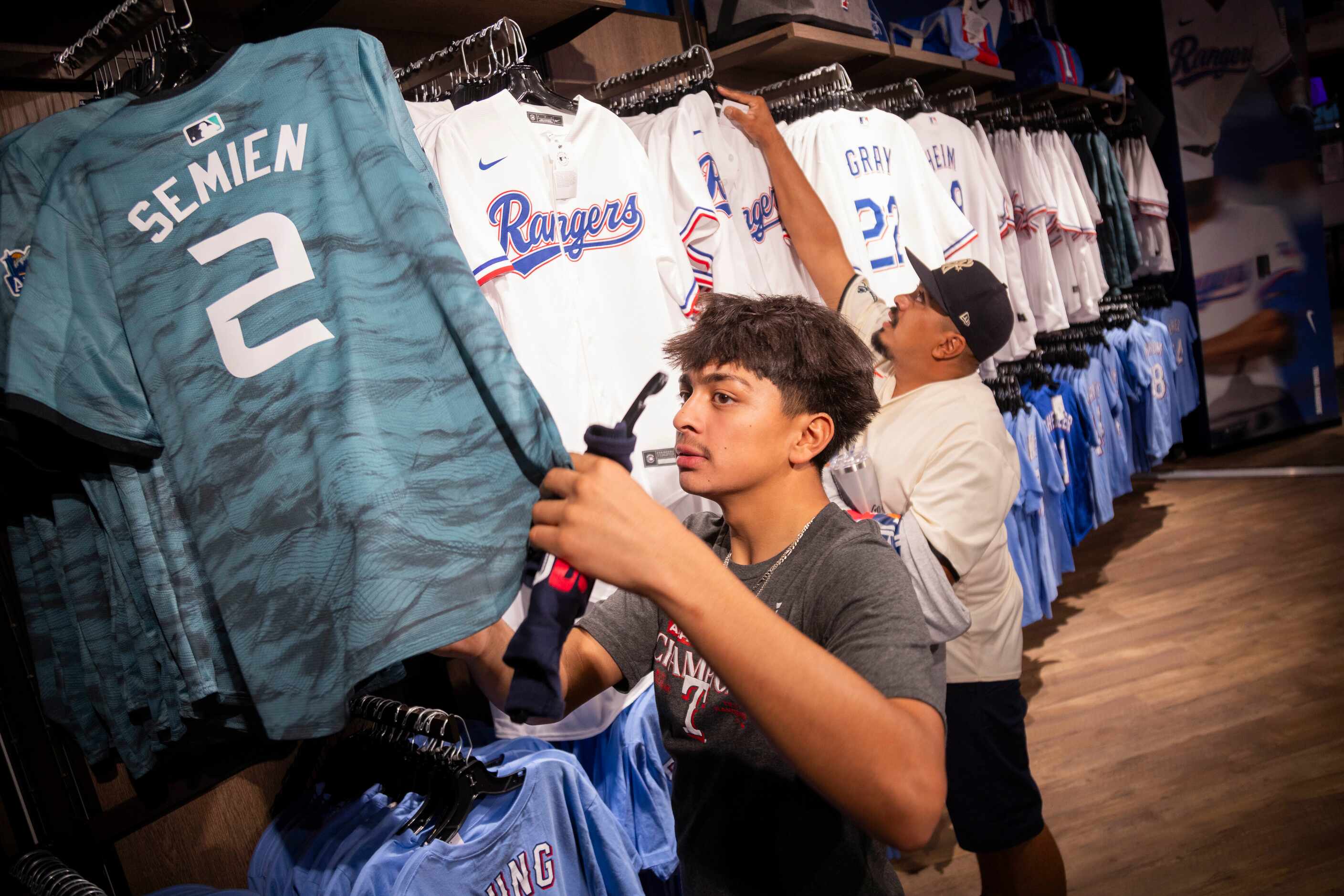 (From left) Michael Ortiz and dad Miguel Ortiz peruse the jerseys on sale at the Grand Slam...