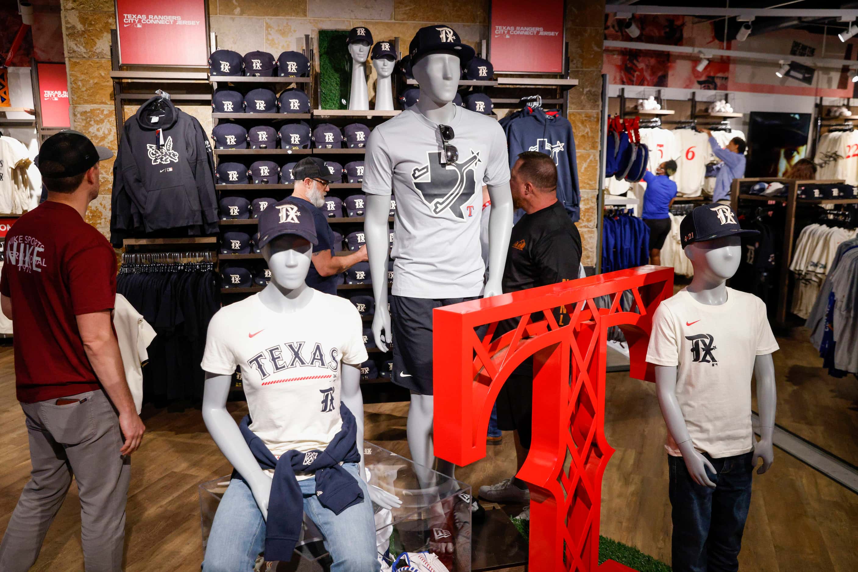 Fans browse the new Texas Rangers City Connect merchandise at Globe Life Field on Monday,...