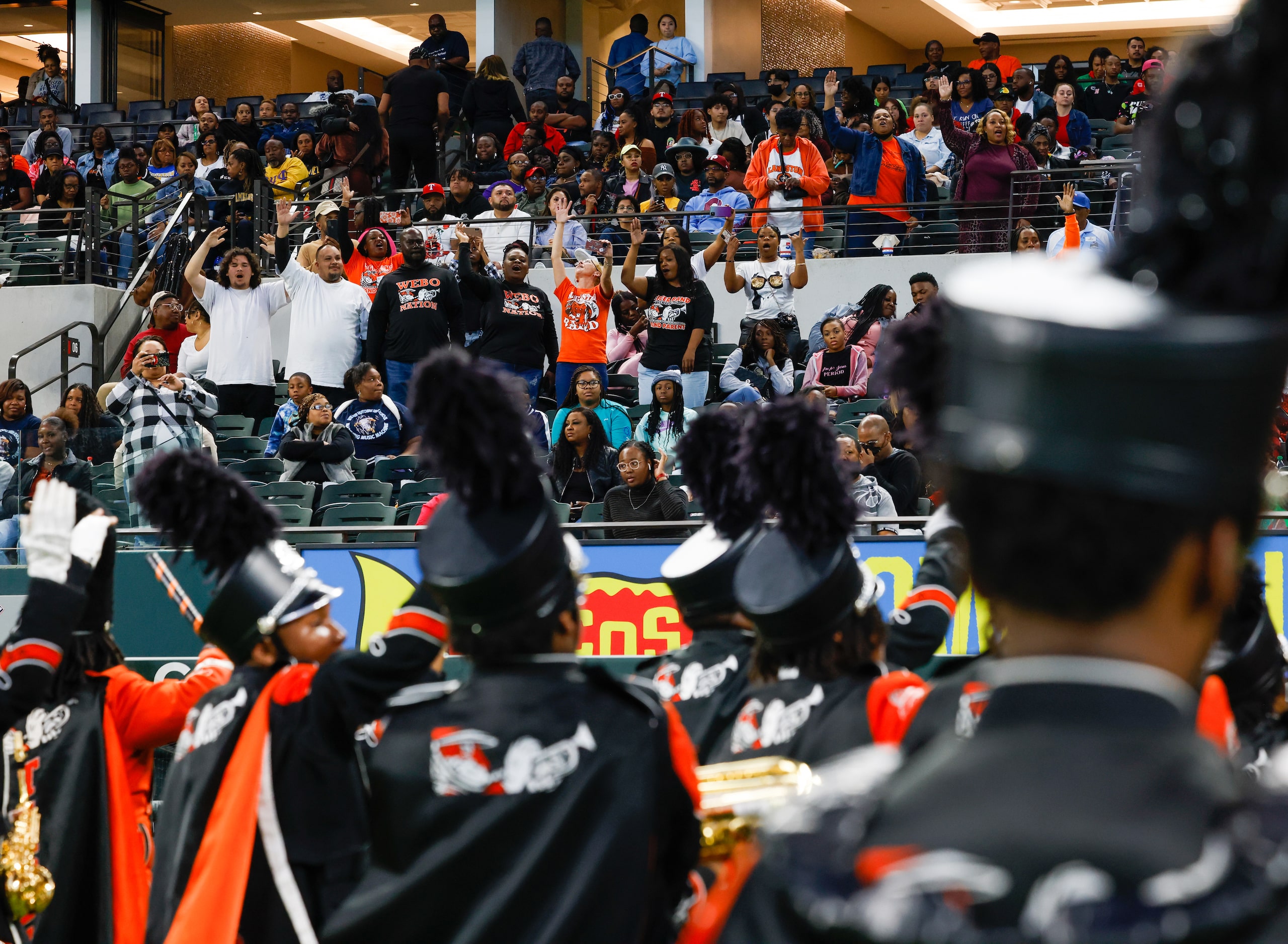 Members of the crowd jump up from their seats to cheer for the Lancaster High School...