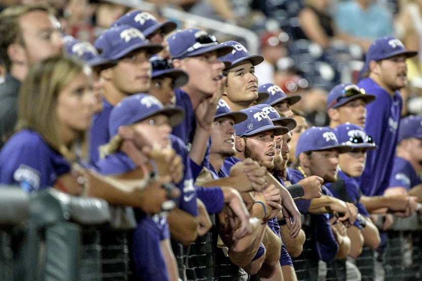 TCU players watch from the dugout in the ninth inning of an NCAA College World Series...