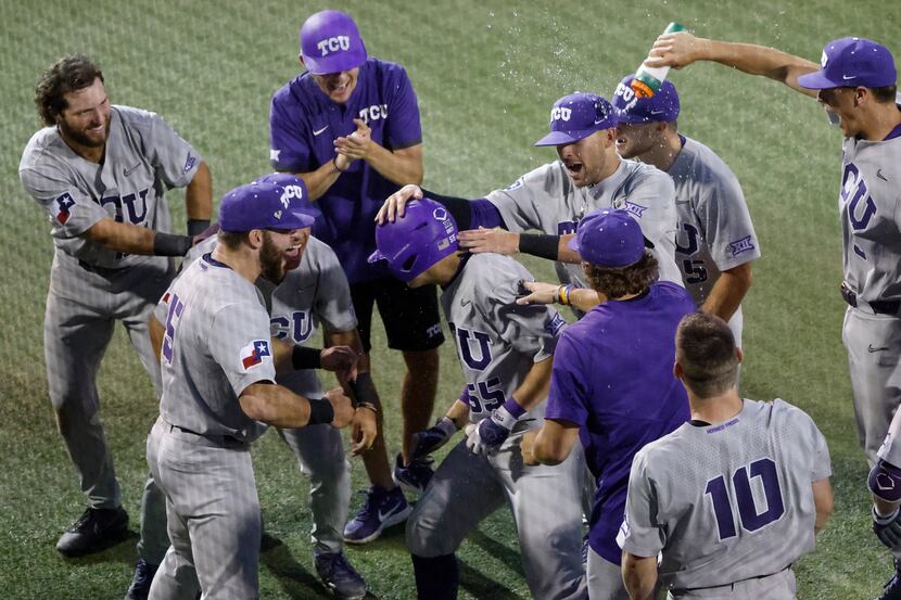 TCU infielder Brayden Taylor (55) is mobbed by teammates after he hit a solo home run...