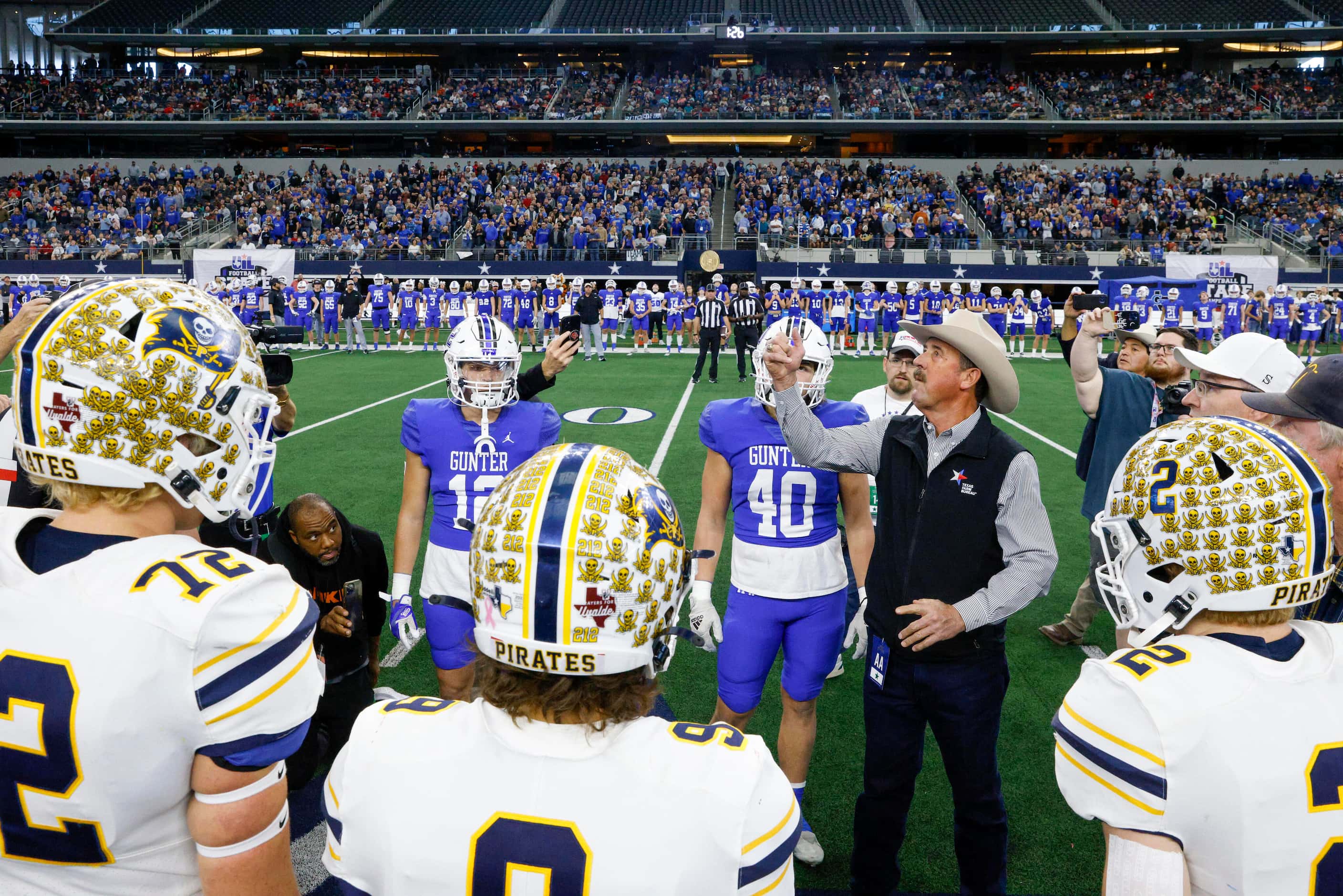 The Poth and Gunter captains watch as the coin toss is performed before the first half of...