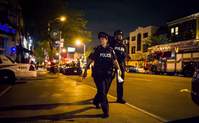 Police secure a perimeter around the scene of a mass shooting in Toronto on Monday.