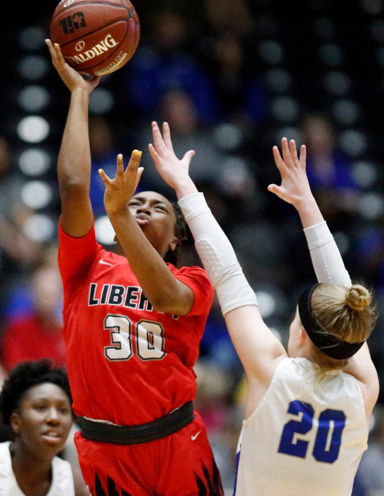 Frisco Liberty High School guard Jazzy Owens-Barnett (30) goes up for a shot over Midlothian...