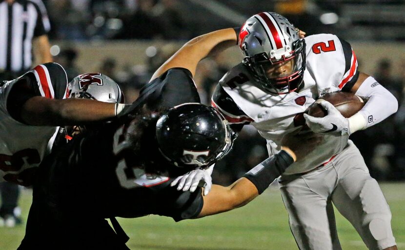 Marcus running back Justin Dinka (2) fights for yardage as Trinity defender Alasaia Fetu'u...