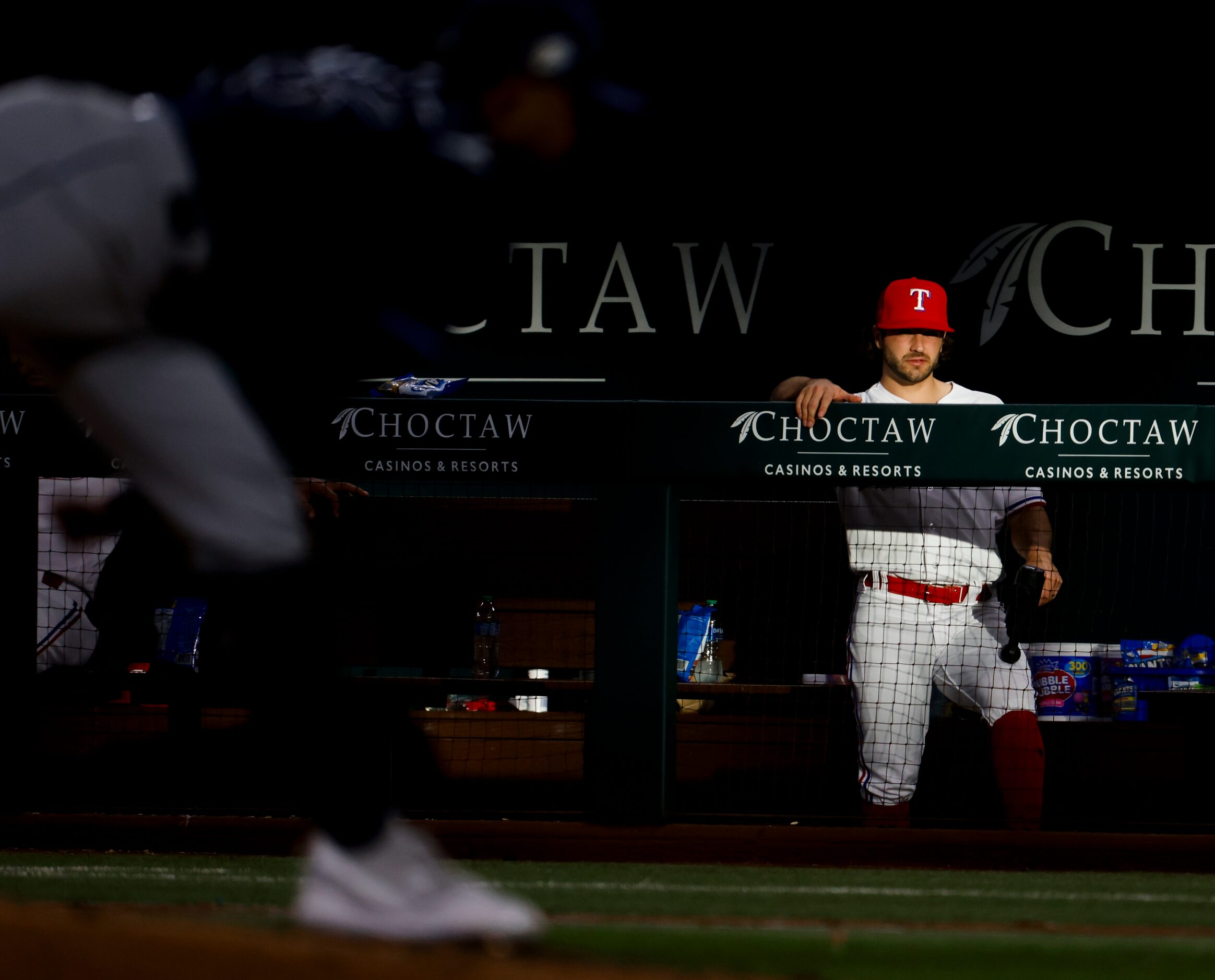 Texas Rangers shortstop Josh Smith stays in the dugout during an inning break of a baseball...