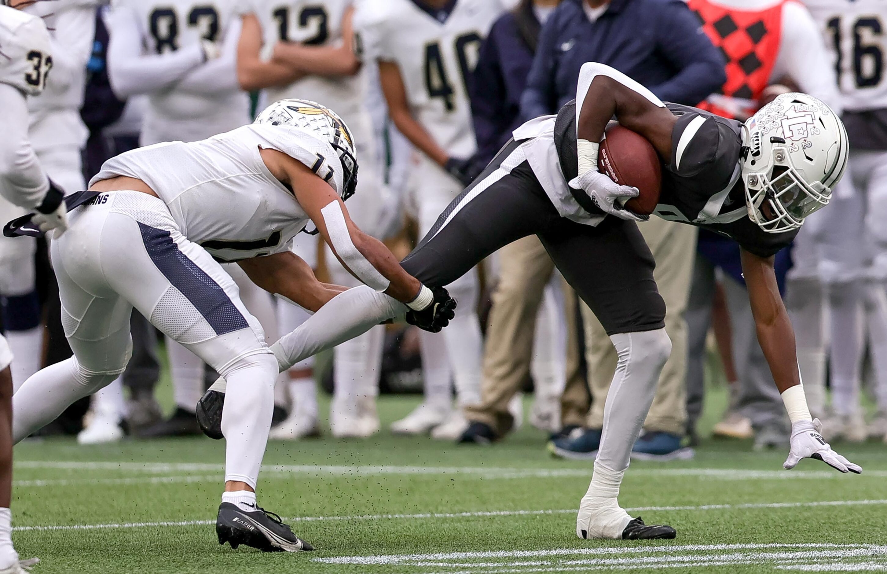 Lewisville wide receiver Lamar Kerby, (right) comes up with a reception and is tackled by...