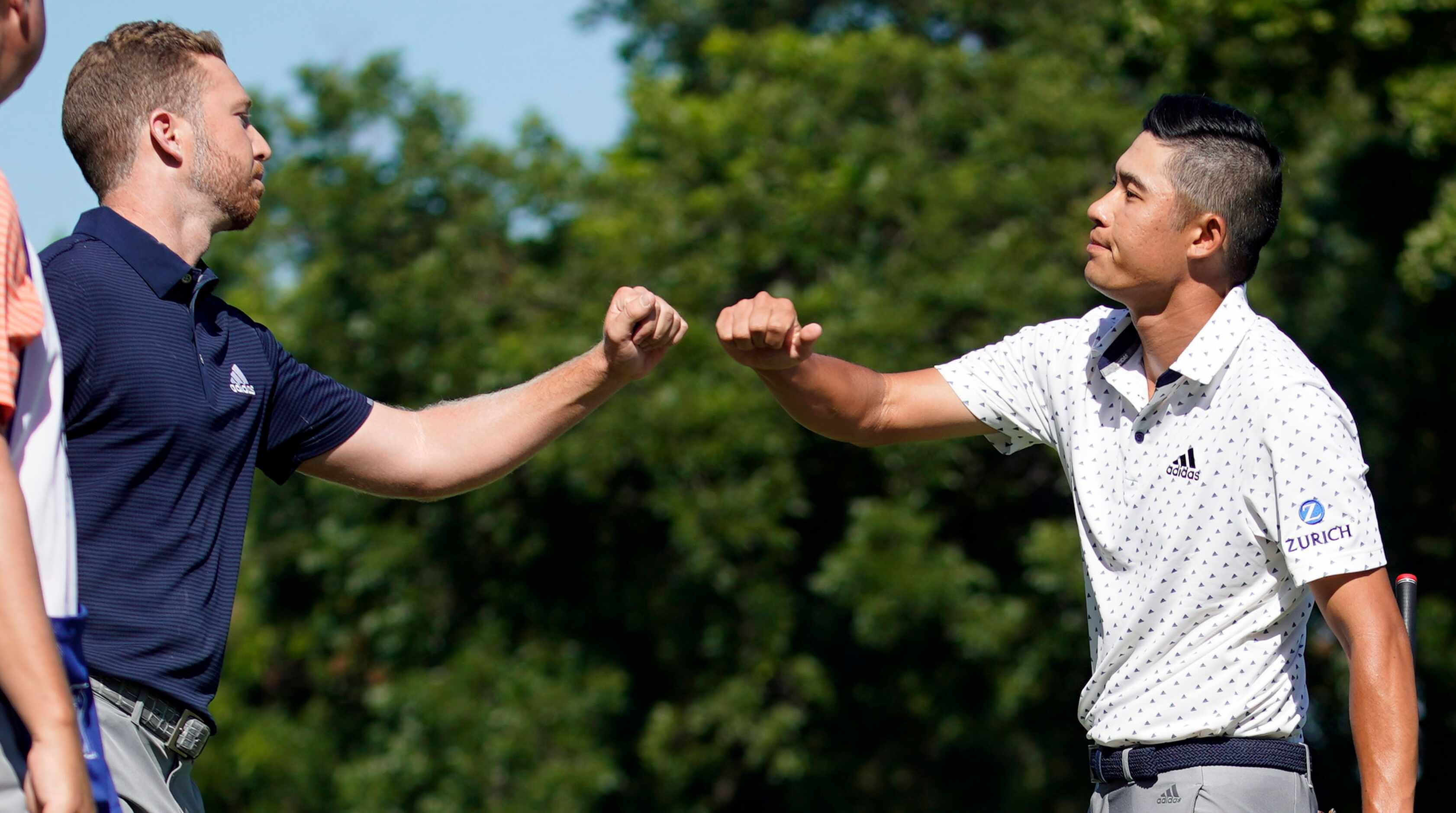 PGA Tour golfer Collin Morikawa gives winner Daniel Berger a fist bump after he missed a...