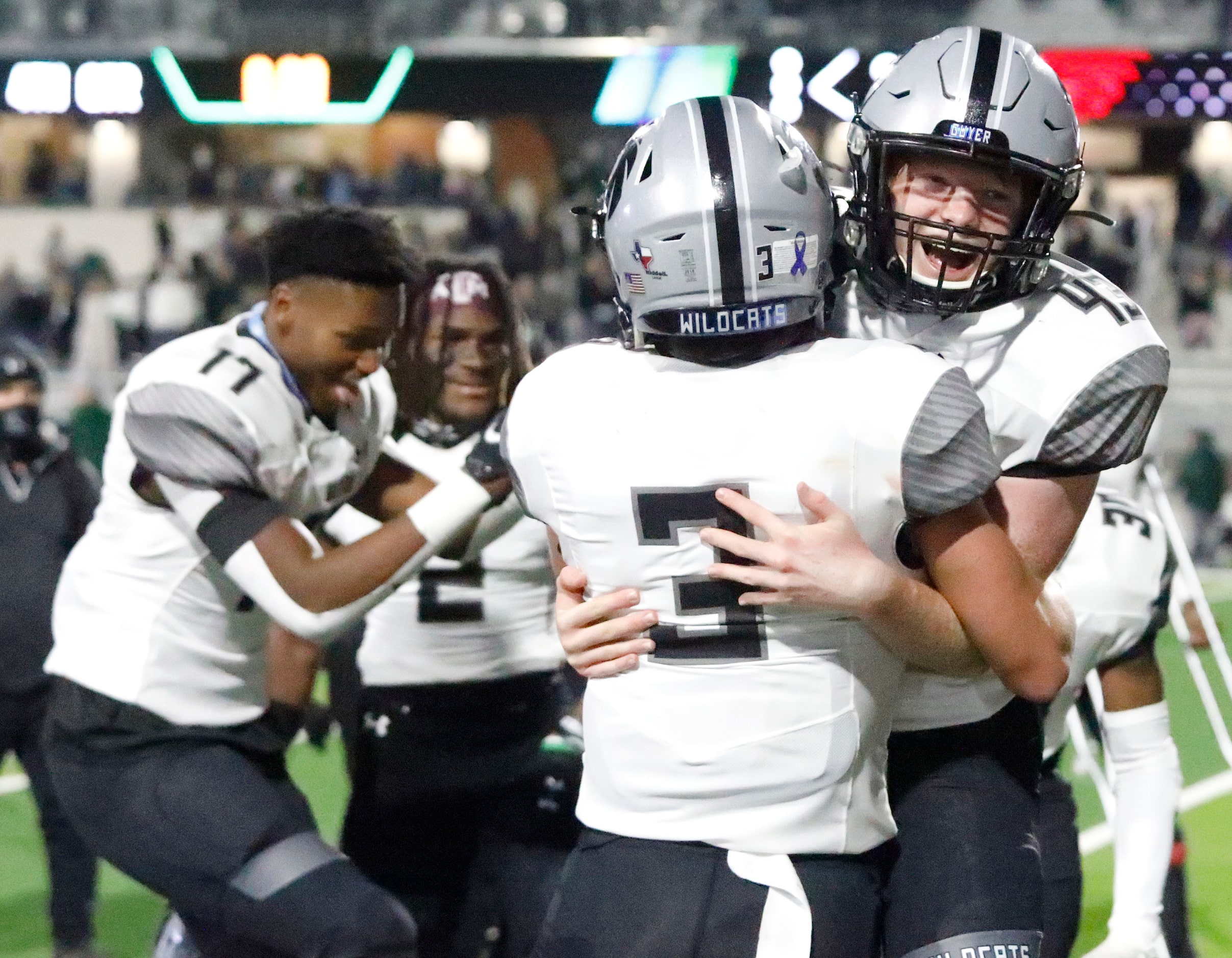 Denton Guyer High School kicker Michael Mayfield (43) is embraced by Denton Guyer High...