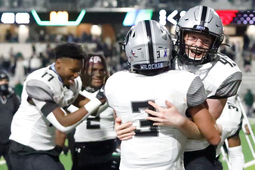 Denton Guyer High School kicker Michael Mayfield (43) is embraced by Denton Guyer High...