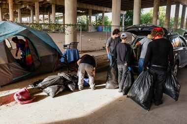 Activists help a couple move their belongings from a homeless encampment along Coombs Street...