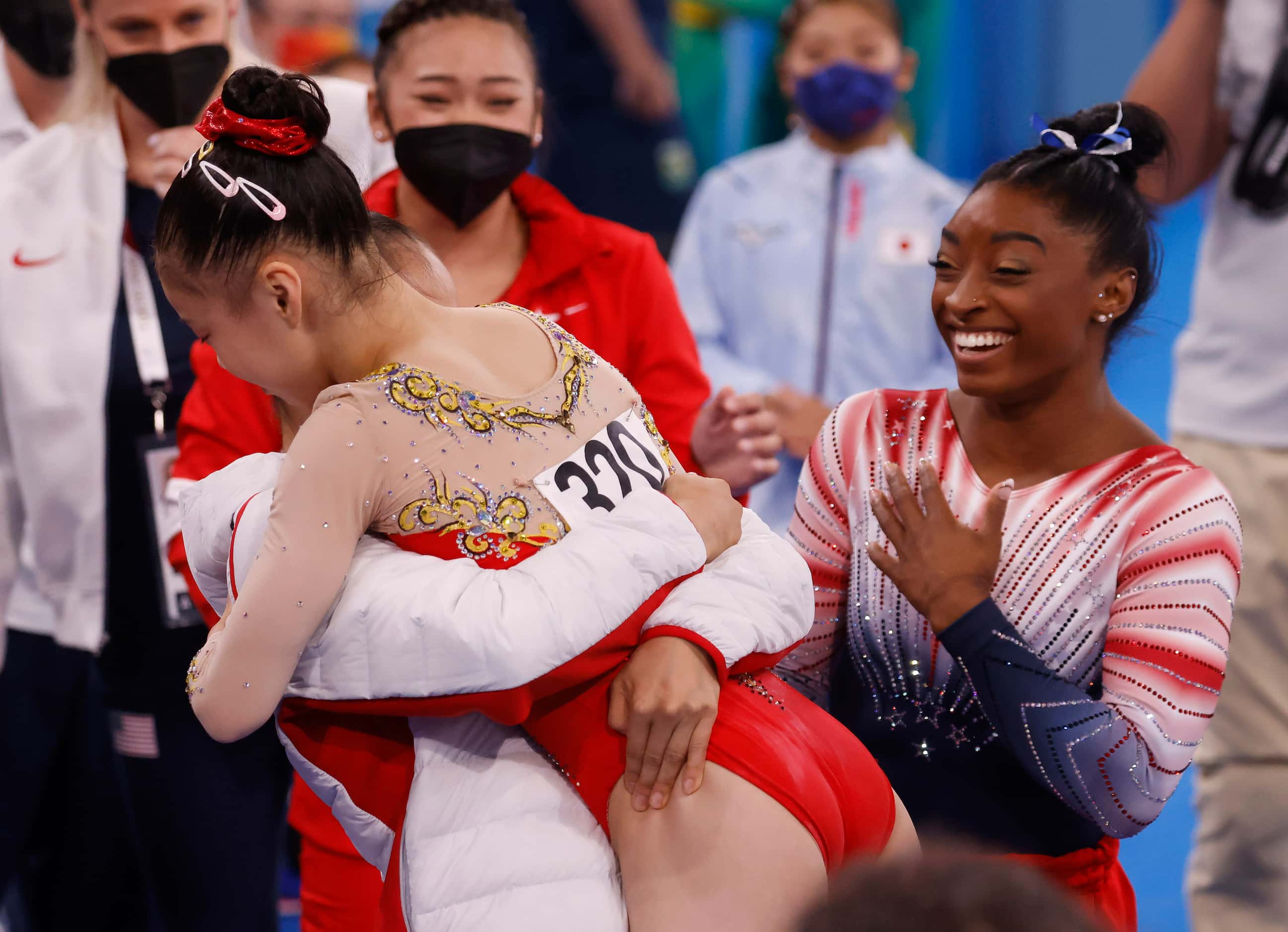 USA’s Simone Biles looks on as China’s Tang Xijing hugs teammate Guan Chenchen after she...