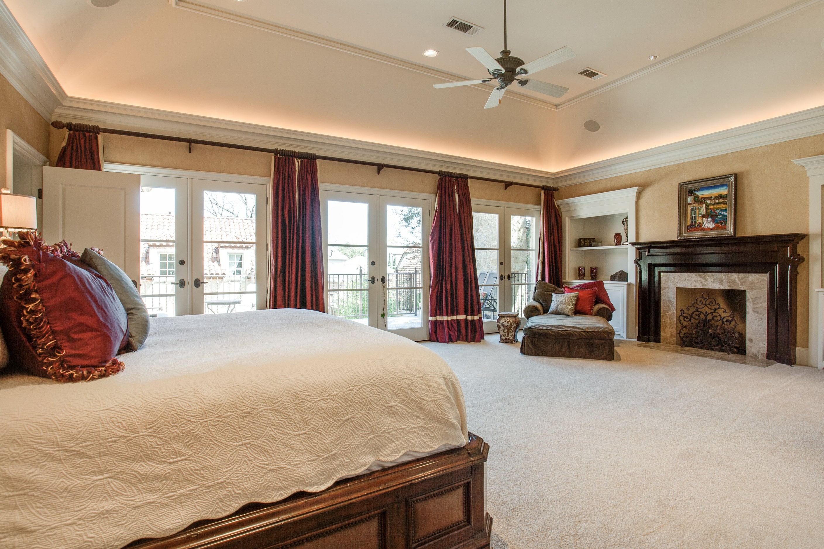 The master suite features vaulted ceilings, large windows and a sitting area with wood...