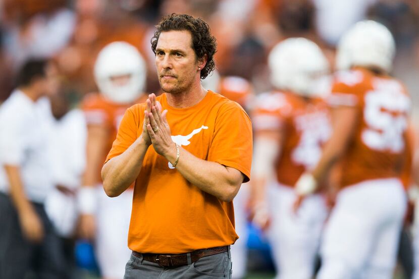 Actor Matthew McConaughey claps on the field before an NCAA football game between the Texas...