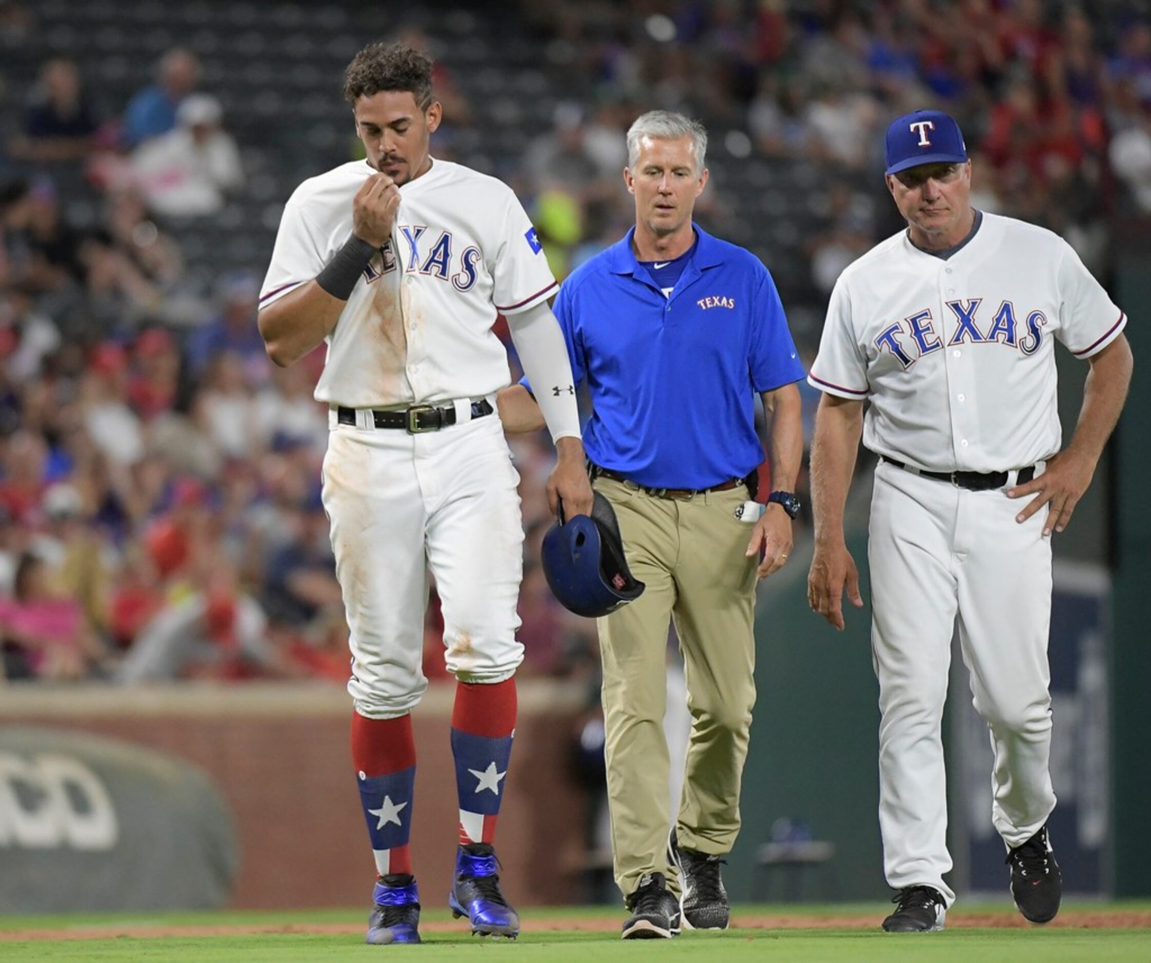 Texas Rangers first baseman Ronald Guzman (67) is injured on a pick off attempt at third...