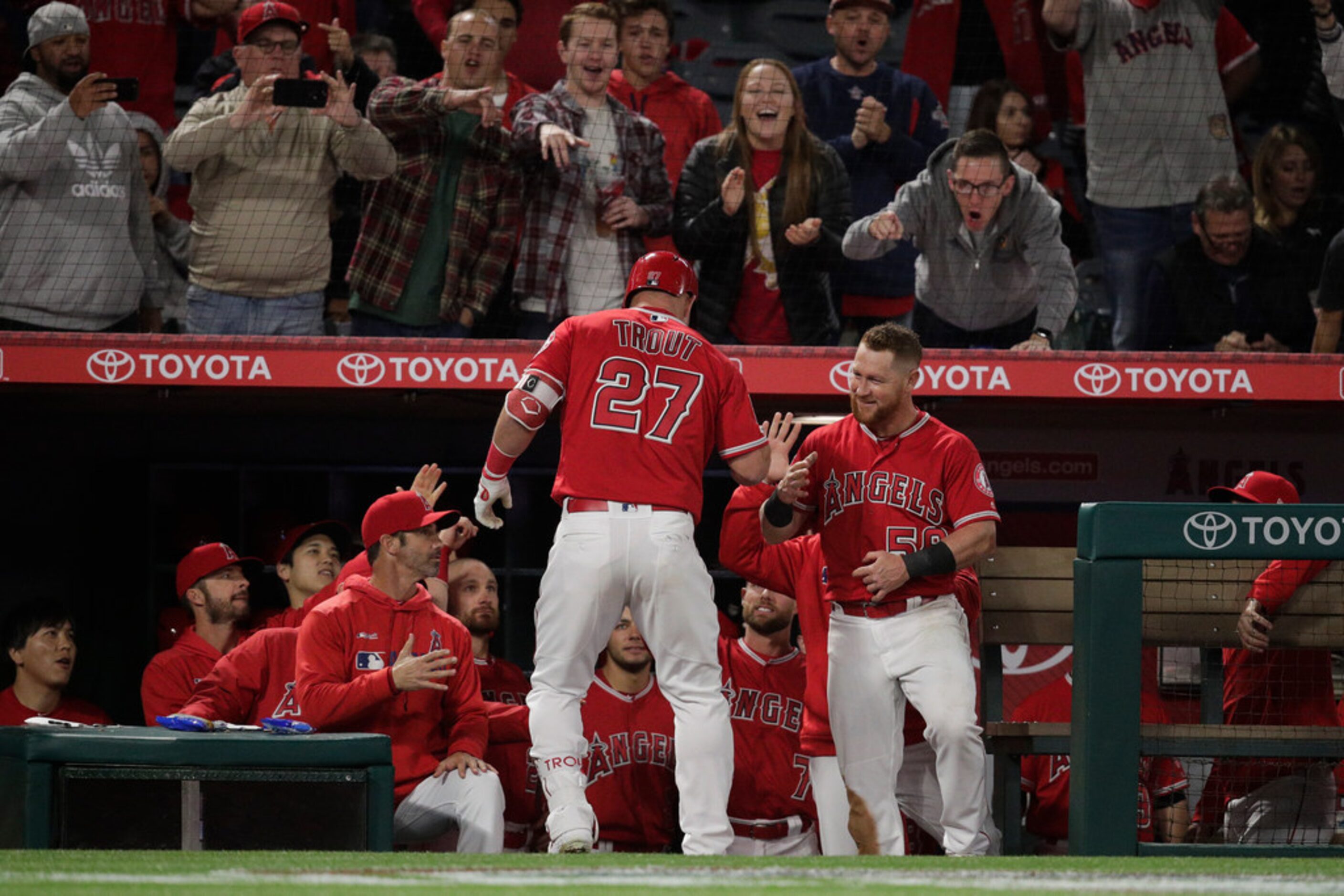 Los Angeles Angels' Mike Trout, center, celebrates his home run with teammates during the...