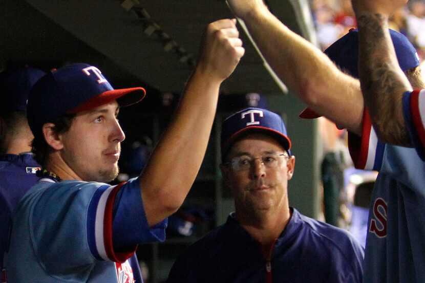 Texas pitcher Derek Holland and special pitching instructor Greg Maddux are pictured in the...