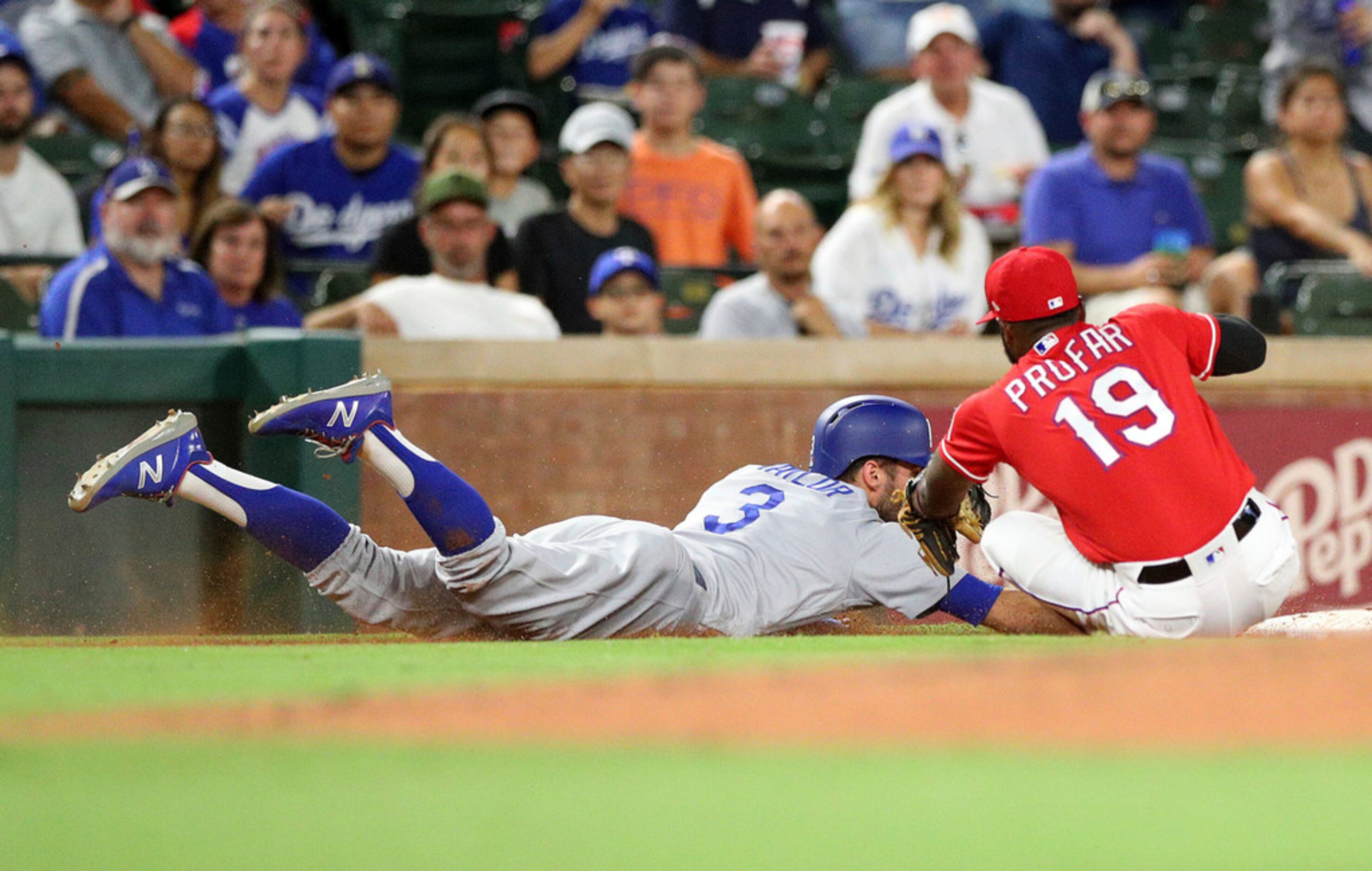 Los Angeles Dodgers' Chris Taylor (3) makes it back to third ahead of the tag by Texas...