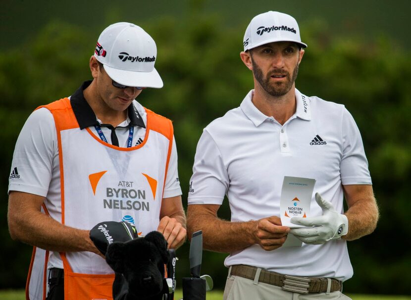 FILE - Dustin Johnson talks with his brother and caddie, Austin Johnson, at the first hole...