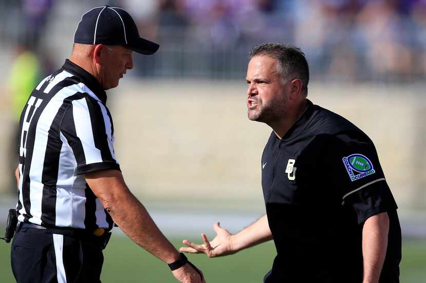 Baylor head coach Matt Rhule, right, questions head linesman Mike Moeller, left, during the...