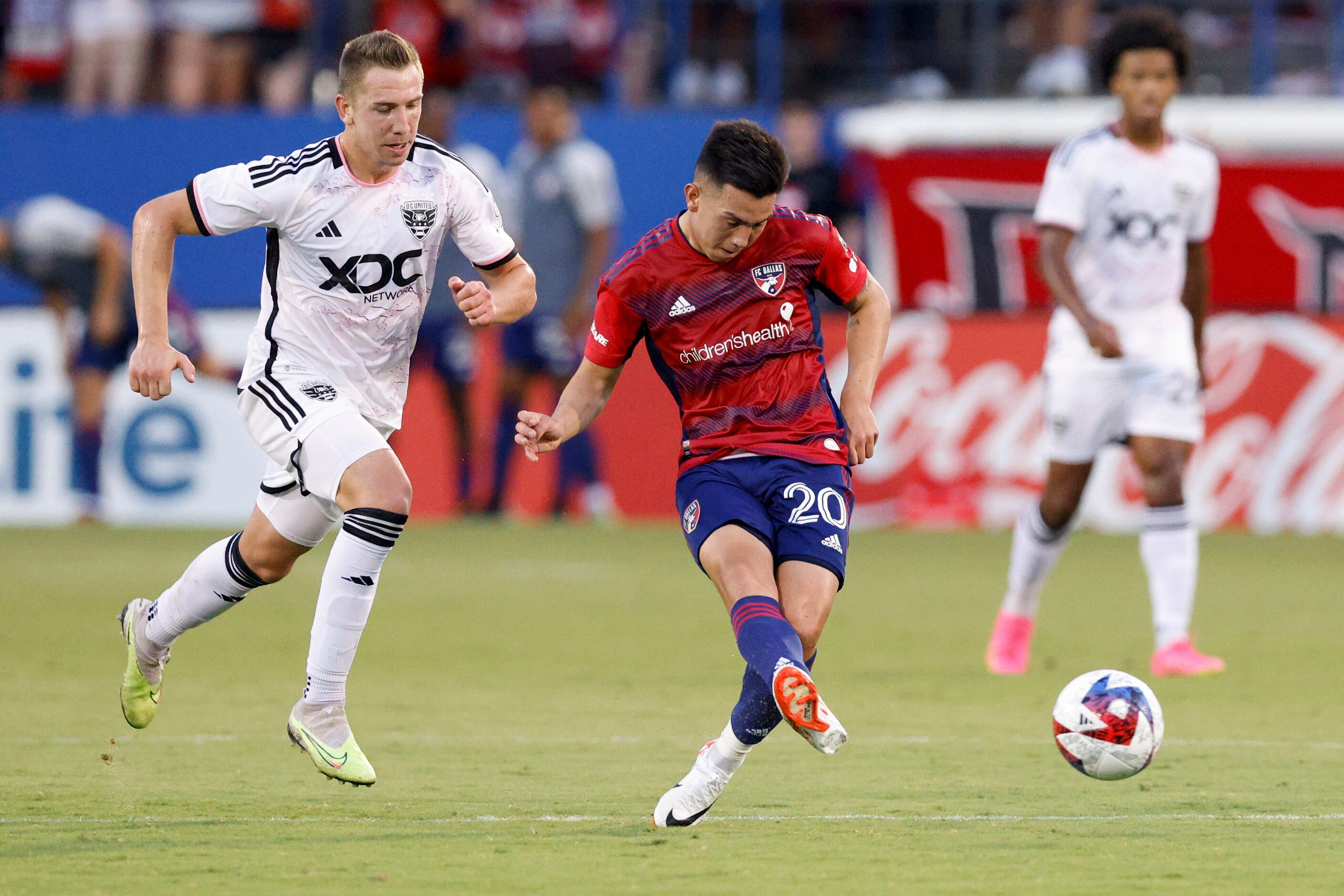 FC Dallas forward Alan Velasco (20) passes the ball away from D.C. United midfielder Russell...