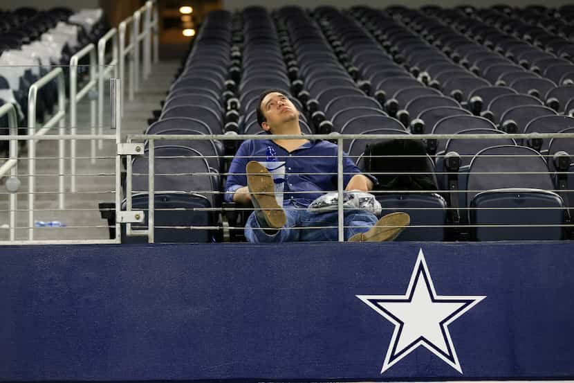 Alfred Ruiz sits in the stands and watches the AFC divisional game on the scoreboard inside...