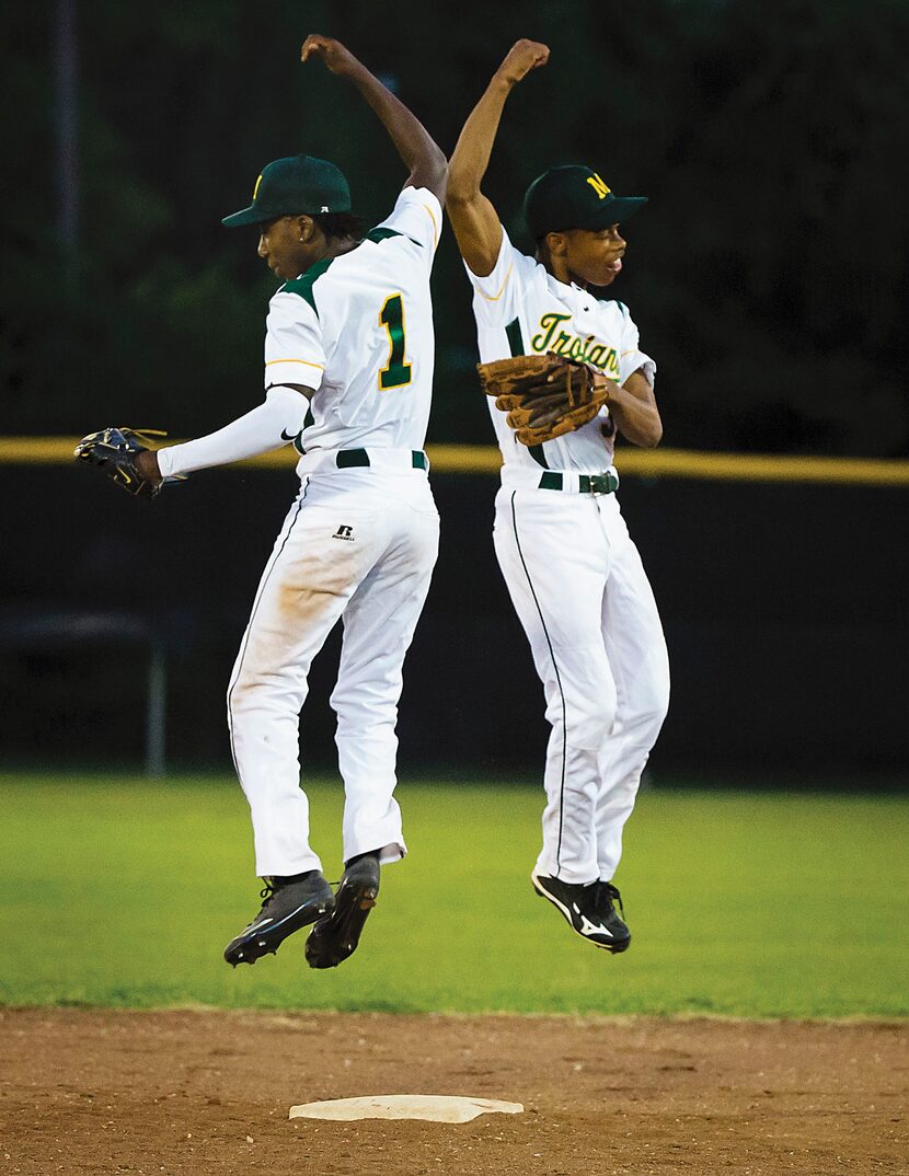 Madison High second baseman David Butler (left) and shortstop Juriod Hollie do a leaping...